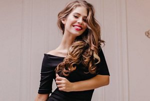 Woman wearing a black dress with long curled hair