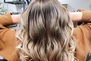 Woman with balayaged bronde hair with a bouncy blow dry