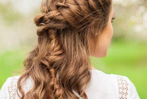 Woman with curly hair in a half-up, half-down hairstyle