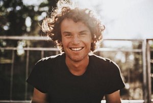 Smiling man with mid-length high-volume curls