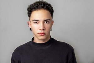 Non-binary person with neat tapered curls