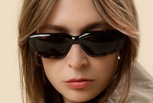 Woman wearing sunglasses with a layered, 80s style curtain fringe