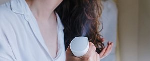 Woman spraying dry shampoo into her hair