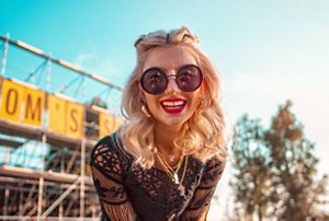 Blonde woman at a festival with tied-back hairline braids