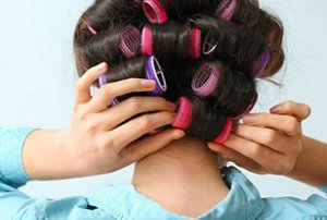 Woman using velcro hair rollers to get fluffy hair