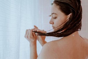 Woman examining her hair after washing it in the shower