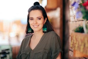 Woman wearing a khaki top with a half-up bun