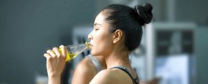 Young Asian woman with a high bun drinking a sports drink