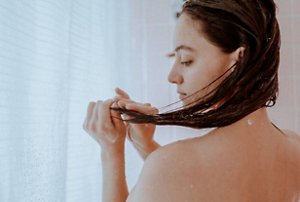 Girl examining her hair after washing it in the shower