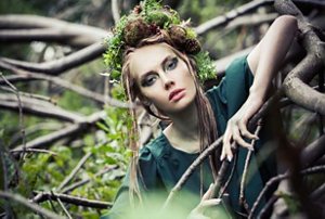 Woman with long braided brunette hair wearing an Earth Goddess costume