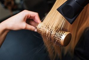 Woman having her hair styled with a boar bristle brush