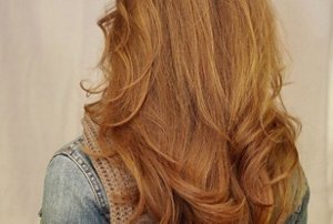 Redheaded woman with long, loose waterfall layers