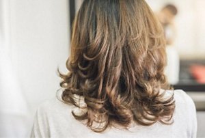 Brunette woman with a coiffed butterfly cut