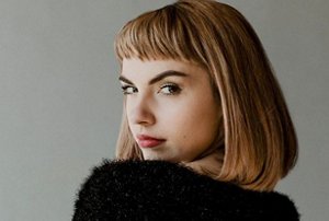 Woman wearing a fluffy jumper with a long blunt-cut bob