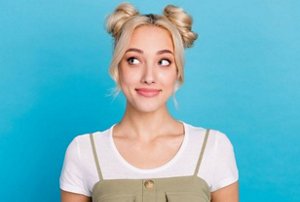 Blonde woman in a 1990s causal outfit with a double bun hairstyle