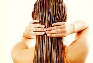 Woman smoothing a nourishing treatment through her lengths