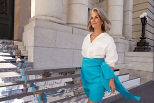 Confident woman wearing a bright blue skirt with a full-looking grey hairstyle