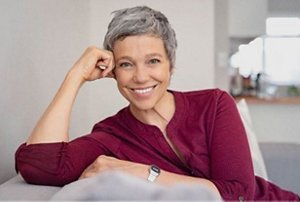 Smiling older woman with grey hair styled in a pixie cut