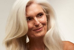 Elegant older woman with natural light grey hair styled in a side parting