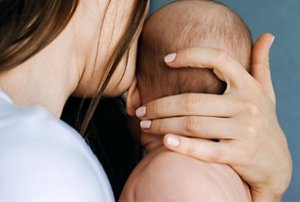 Woman holding her newborn baby close to her