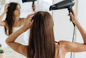 Woman drying her hair with a hairdryer