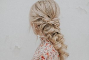 Blonde woman with a long, thick fishtail braid hairstyle