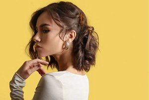 Girl in a white prom dress with a half-up half-down hairstyle