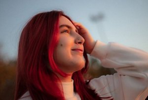 Woman standing in the dusk with red hair