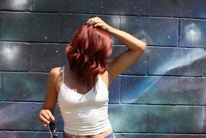 Woman with red hair standing against a galaxy background