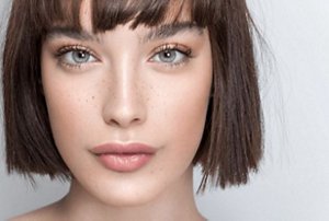 Brunette woman with a sharply-angular blunt-cut bob