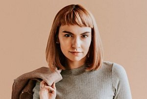 Young woman with auburn hair cut in a blunt shoulder-length style