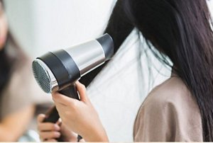 Woman drying her hair using a diffuser