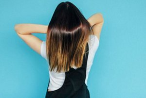 Young woman showing off her glossy long hair