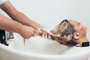Woman having her hair washed with sulphate-free shampoo