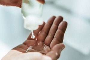 Close-up of a hand squeezing shampoo into an outstretched palm