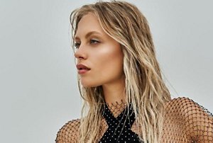 Woman with long blonde hair with dark brunette roots