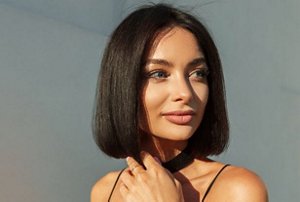 Woman with natural black hair cut into a neat bob