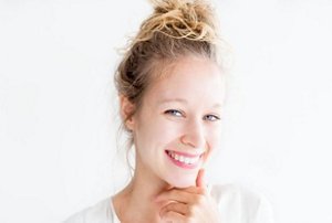 Woman wearing a white t-shirt with a messy bun updo hairstyle