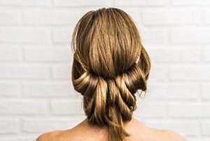 Woman with bronde hair with a low updo hairstyle