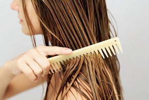 Woman combing a hair serum through her lengths