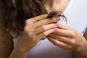 Woman looking at the ends of her hair