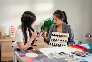 Woman in a salon choosing a semi-permanent tint for her hair with her stylist