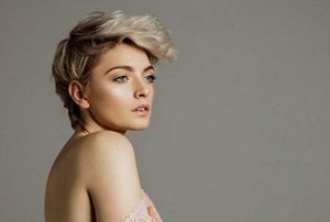 Young blonde woman with a long, styled pixie cut hairstyle