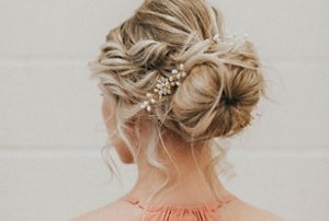 Blonde wedding guest with a styled, structured updo
