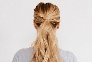 Woman with golden blonde hair tied back in a ponytail