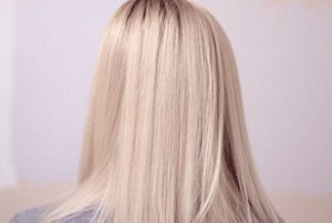 Woman with long ash blonde hair with subtle highlights