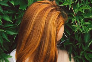 Woman with brick red hair with natural highlights