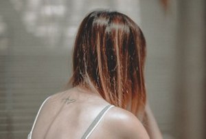 Brunette woman with long, shiny hair with subtle blonde balayage