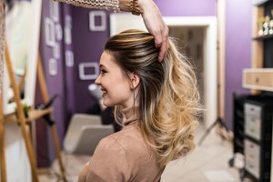 Smiling woman having blonde babylights applied in a salon