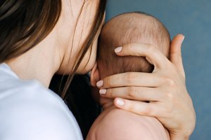 Young woman cradling a newborn baby